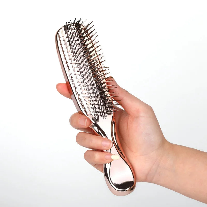Hand holding rose gold scalp massage comb – easy-grip ergonomic design for effortless grooming