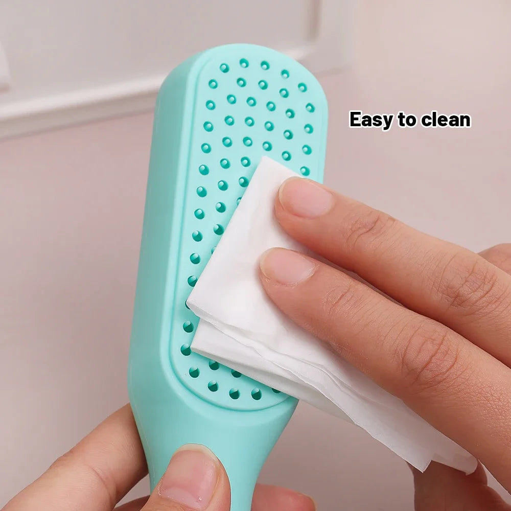 Close-up of hand wiping mint telescopic comb for easy cleaning