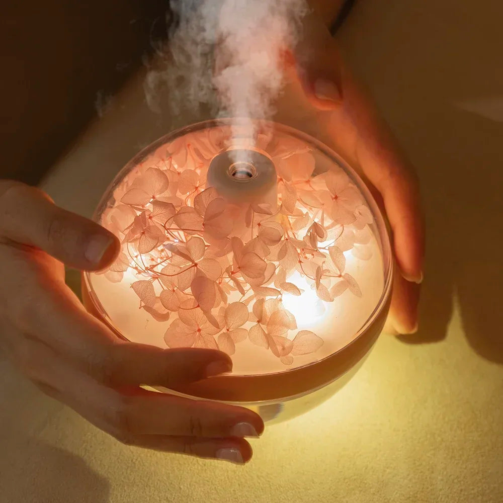 Hand holding a diffuser emitting steam with a warm glow