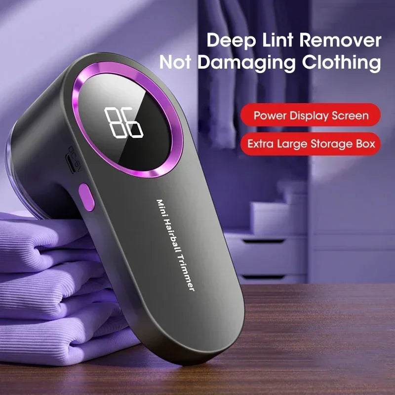 Grey Lint Remover For Clothing on a stack of purple clothing, featuring power display screen and extra large storage box.