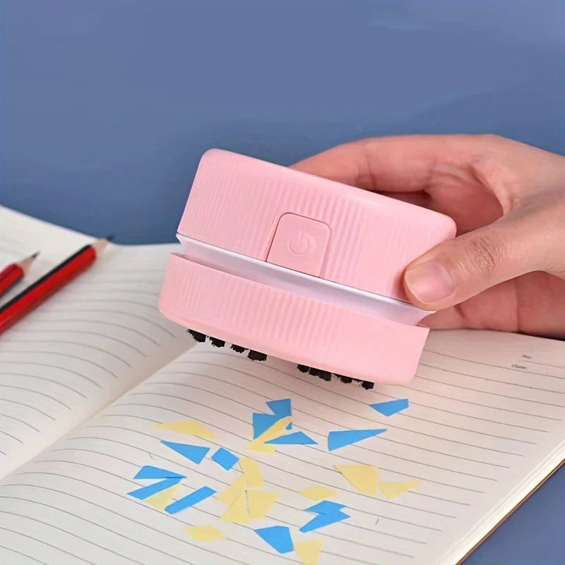 Pink handheld device being used on a notebook with colorful designs.