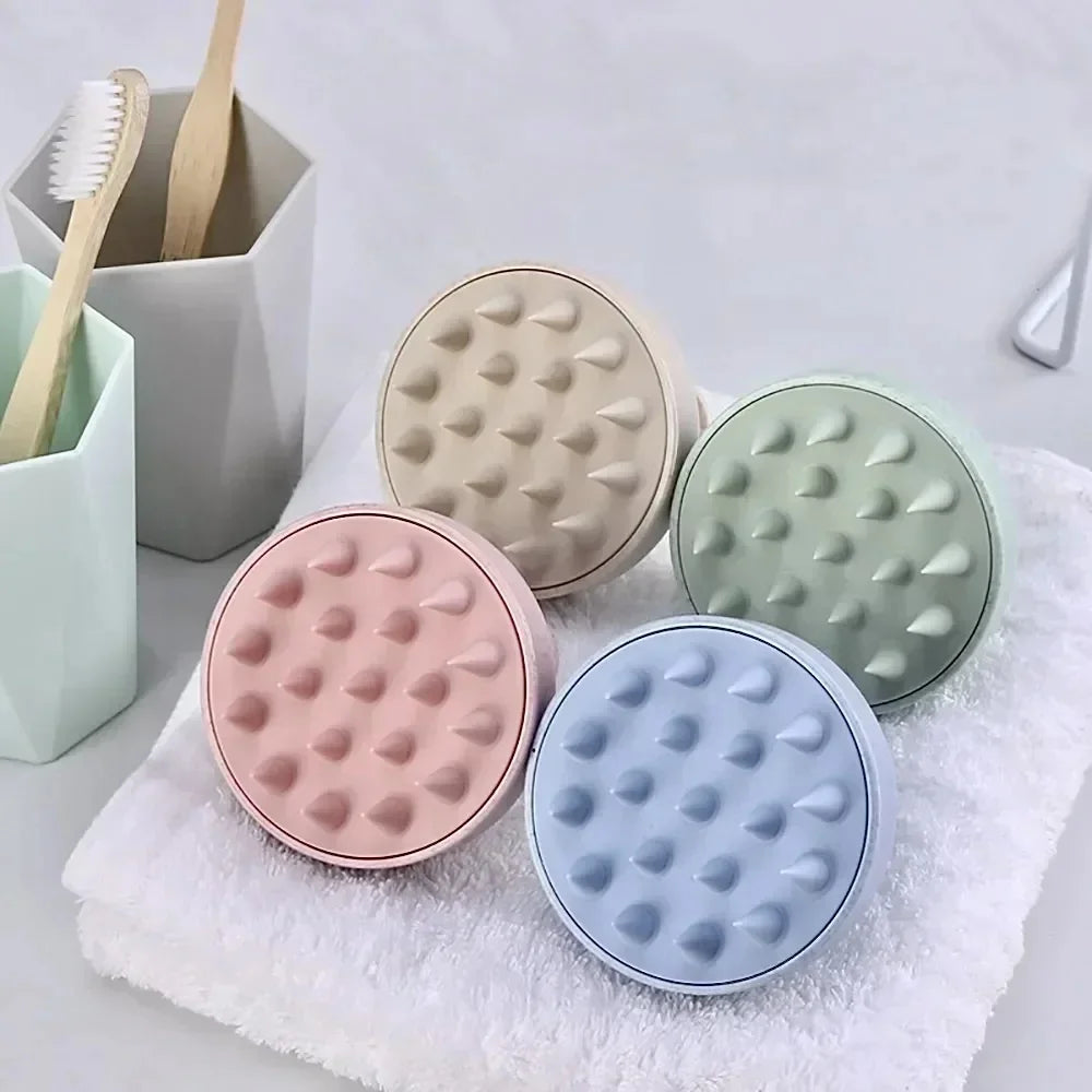 Four round containers with textured surfaces in pastel colors on a towel.